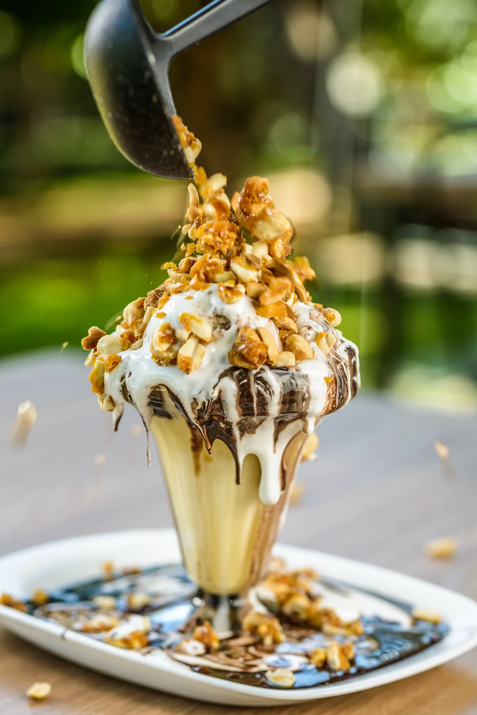 Taça de sorvete com calda de chocolate e castanhas caramelizadas